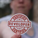 Close-up of a certified developer badge being held outdoors.